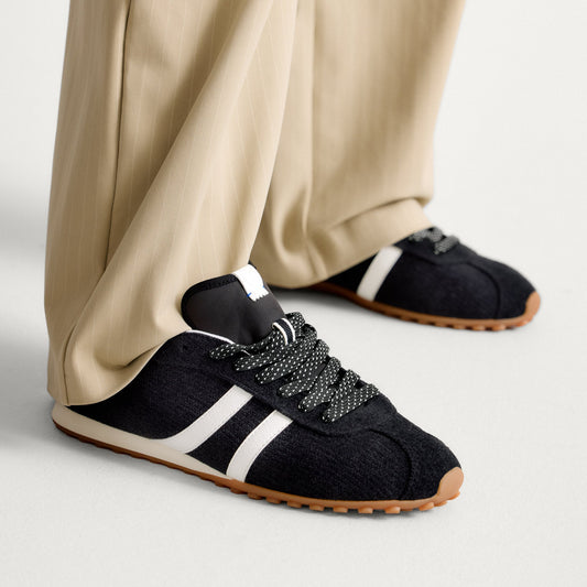 hover | Model wearing The Ivy Sneaker in ReVelvet Black.