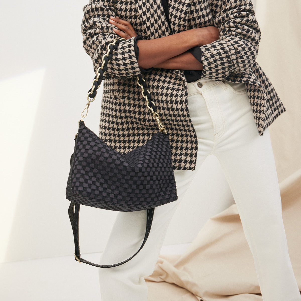 Overlay:: Shown with The Shoulder Strap (sold separately.) | Alt:: The Daily Crossbody in Black Sand paired with The Shoulder Strap in Black being carried by a model from a different angle.