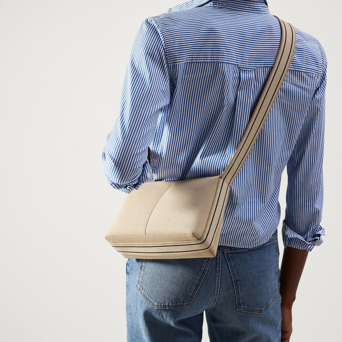 hover | The Casual Crossbody in Parchment, worn as a crossbody by a model, shown from the front.