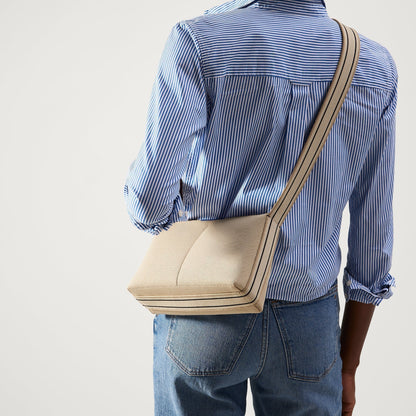hover | The Casual Crossbody in Parchment, worn as a crossbody by a model, shown from the front.