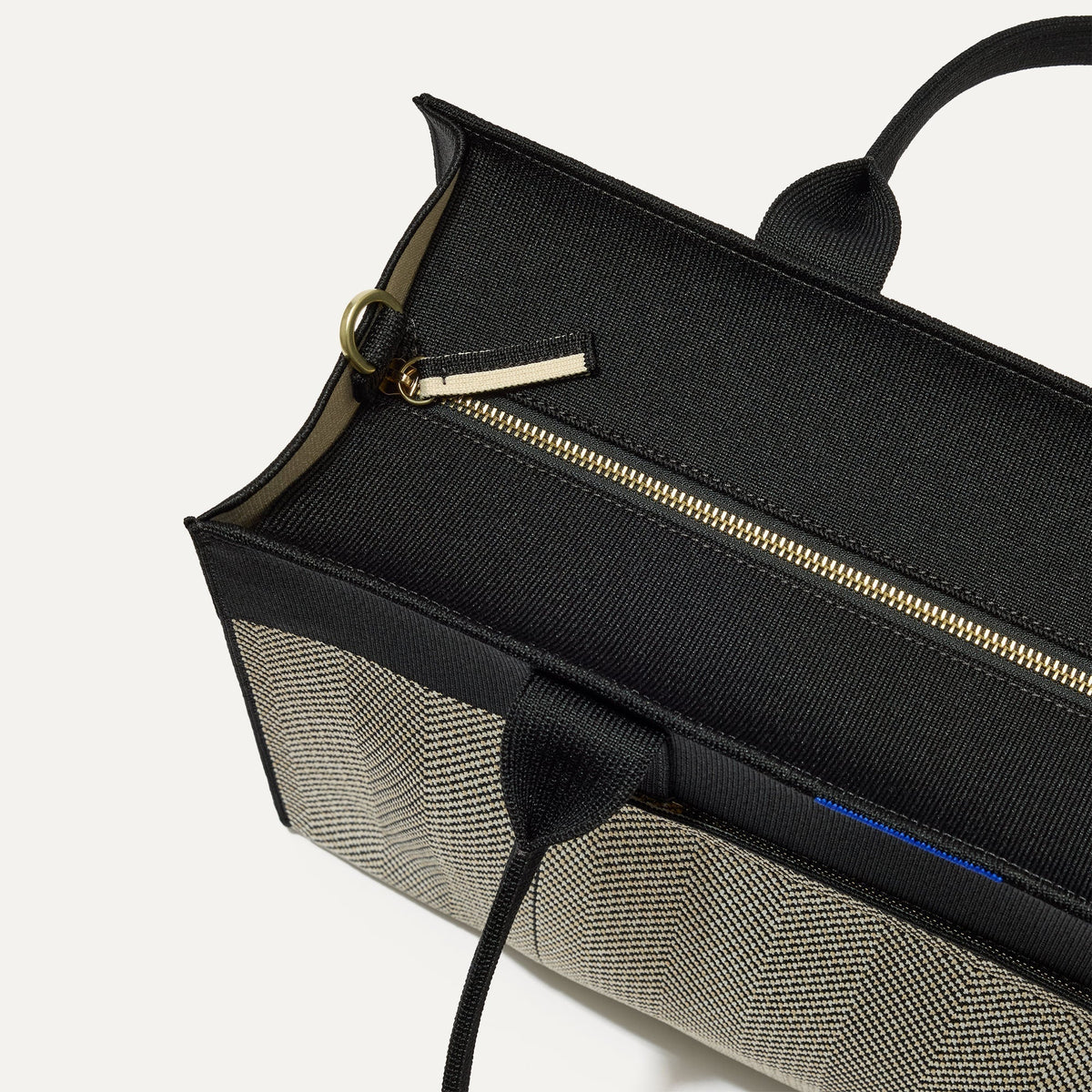The Classic Tote in Black Herringbone, shown from above, with the top zipper closed.