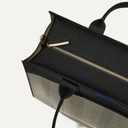The Classic Tote in Black Herringbone, shown from above, with the top zipper closed.