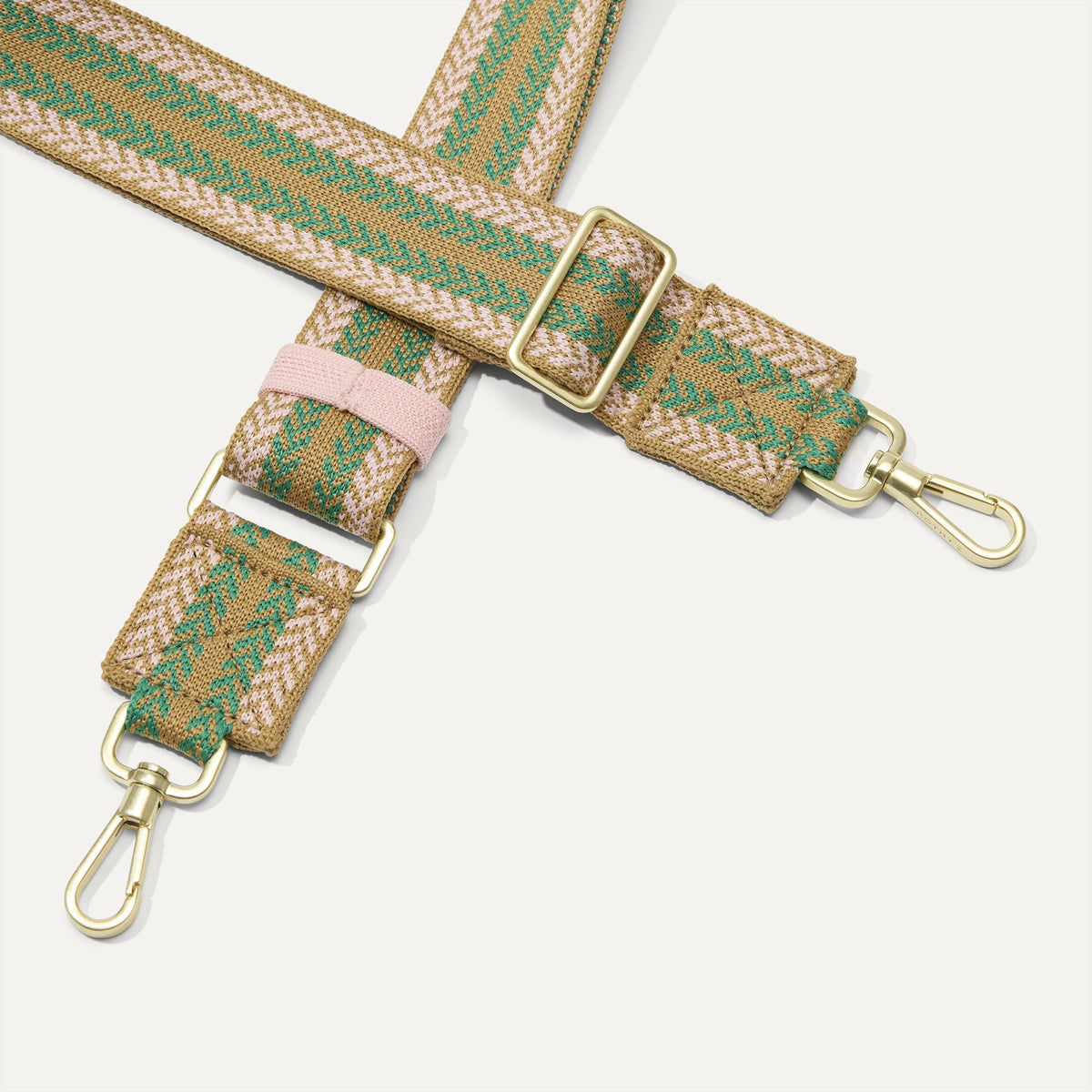 A close-up of The Crossbody Strap in Earthy Chevron, focusing on the end snap hooks and sliding buckle.