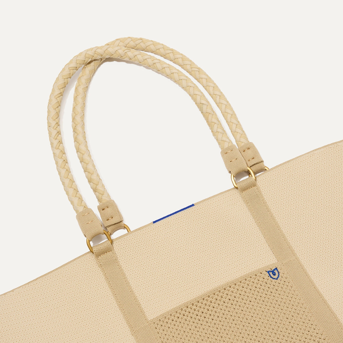 A close up of The Summer Tote in Meringue focusing on the pocket and handles.