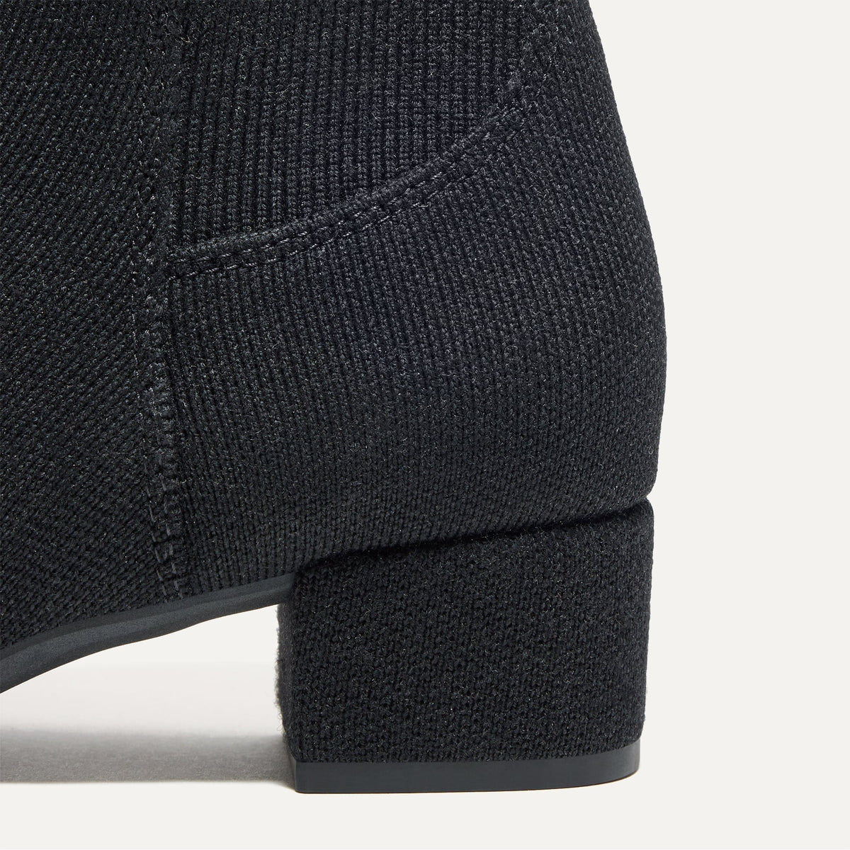 Close up of the block heel of The Classic Boot in Black.