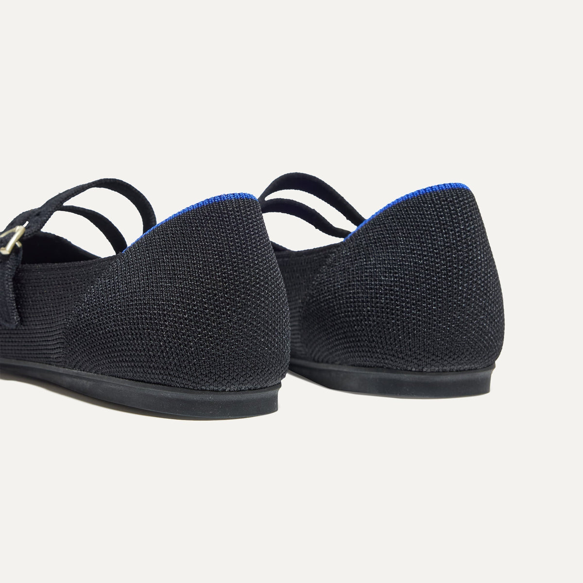 Close up of the heel of The Double Buckle Mary Jane in Black, with Rothy's signature blue halo.
