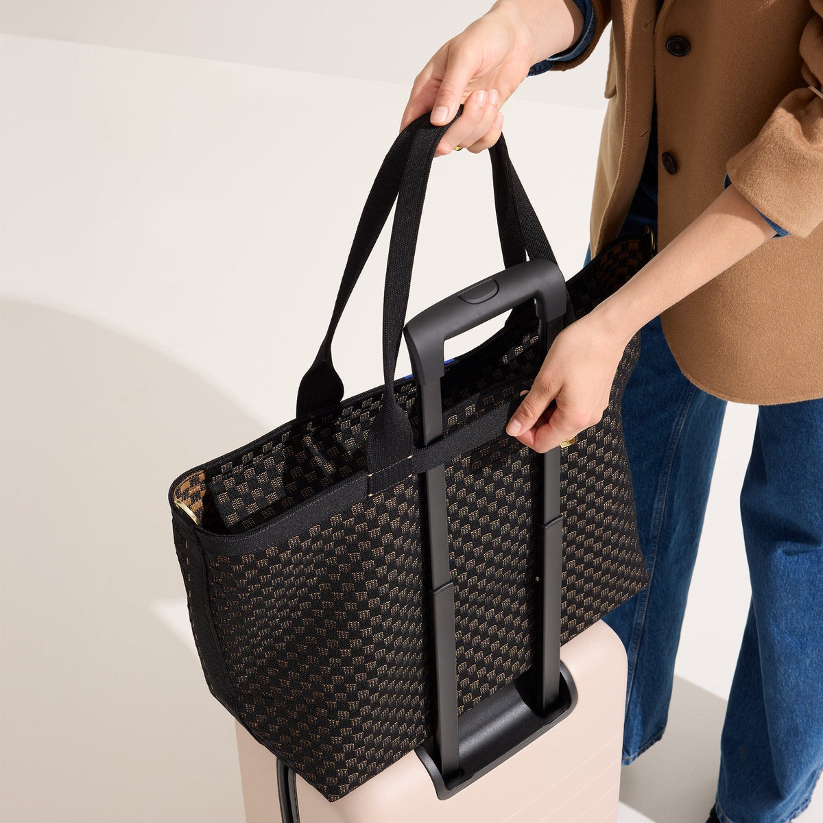 hover | Model holding The Zip Travel Tote in Night Song.