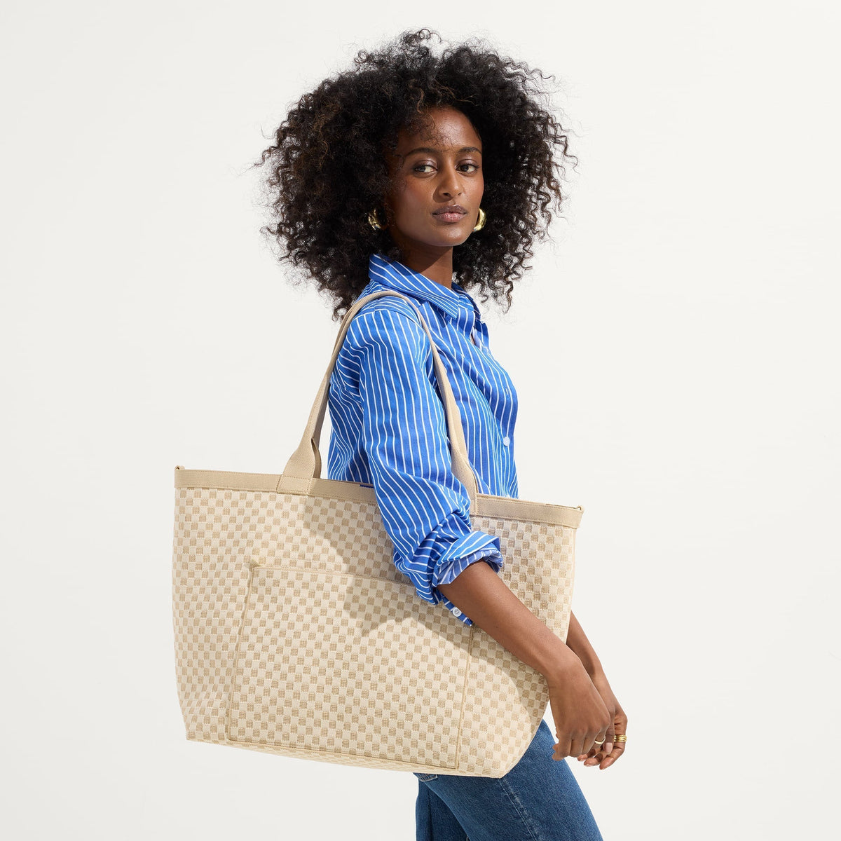 hover | Model holding The Zip Travel Tote in Parchment Basketweave.