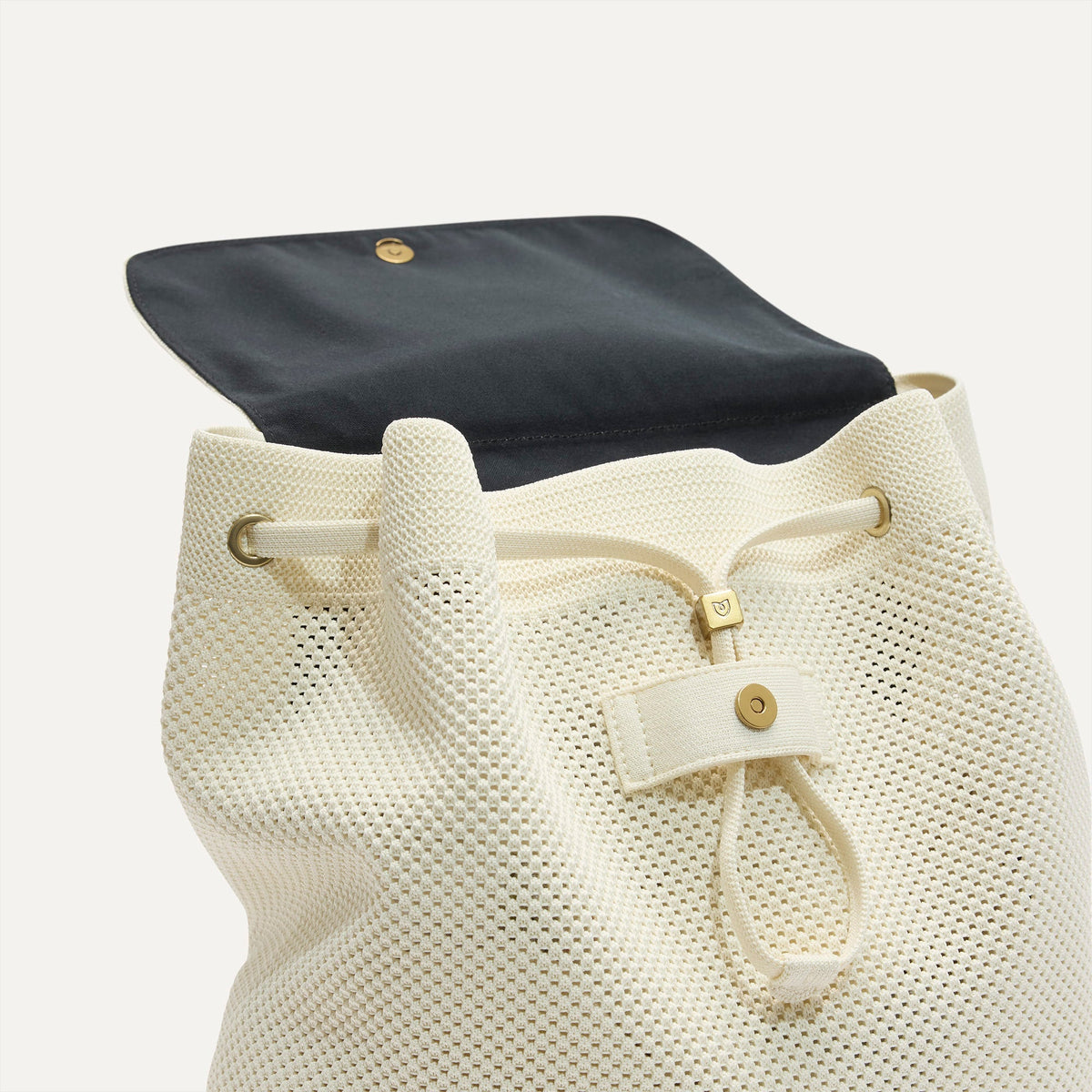 A close up of The Cinch Backpack in Coconut Crochet showing the drawstring closure.