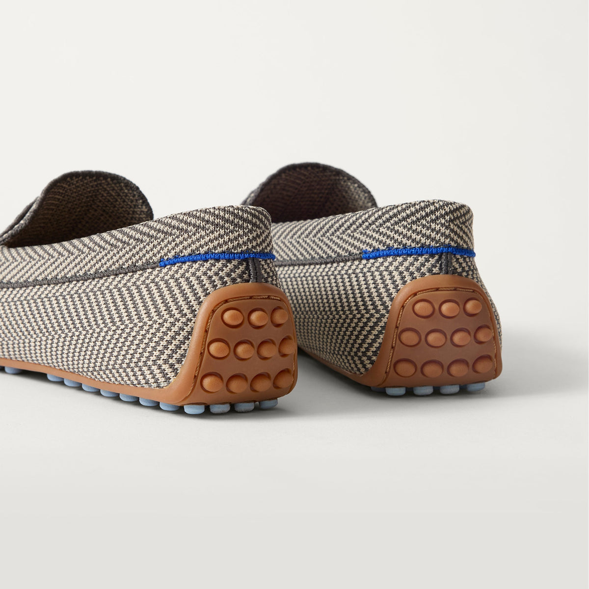Close up of the heel of The Daily Driver in Iron Herringbone, with raised peg outsoles and Rothy's signature blue halo.