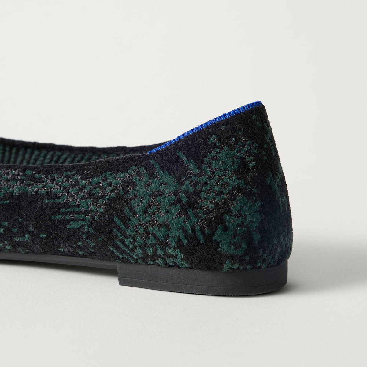 Close up of the heel of The Point III in ReVelvet Evergreen Python, with Rothy's signature blue halo.