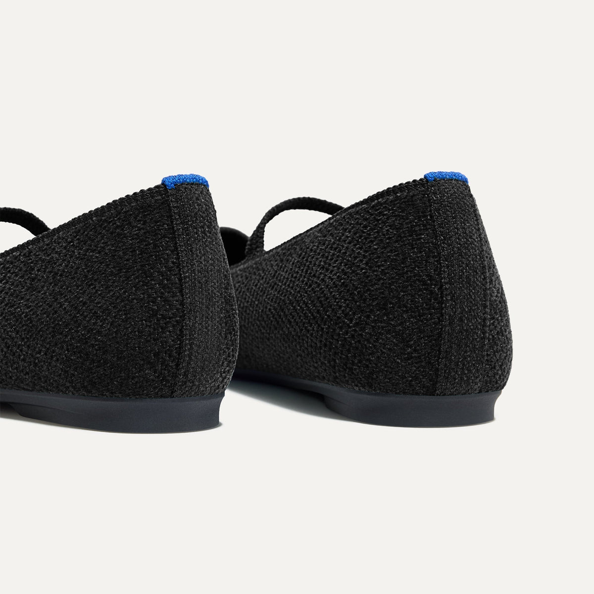 Close up of the heel of The Max Square Mary Jane in ReVelvet™ Black, with Rothy's signature blue halo.