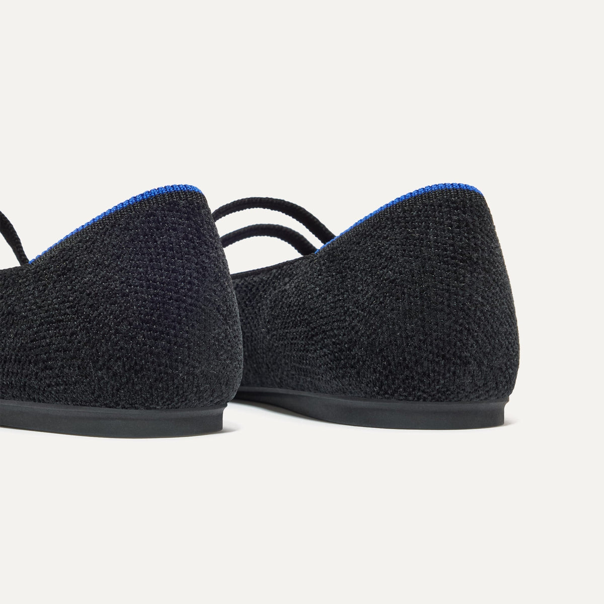 Close up of the heel of The Double Buckle Mary Jane in ReVelvet™ Black, with Rothy's signature blue halo.
