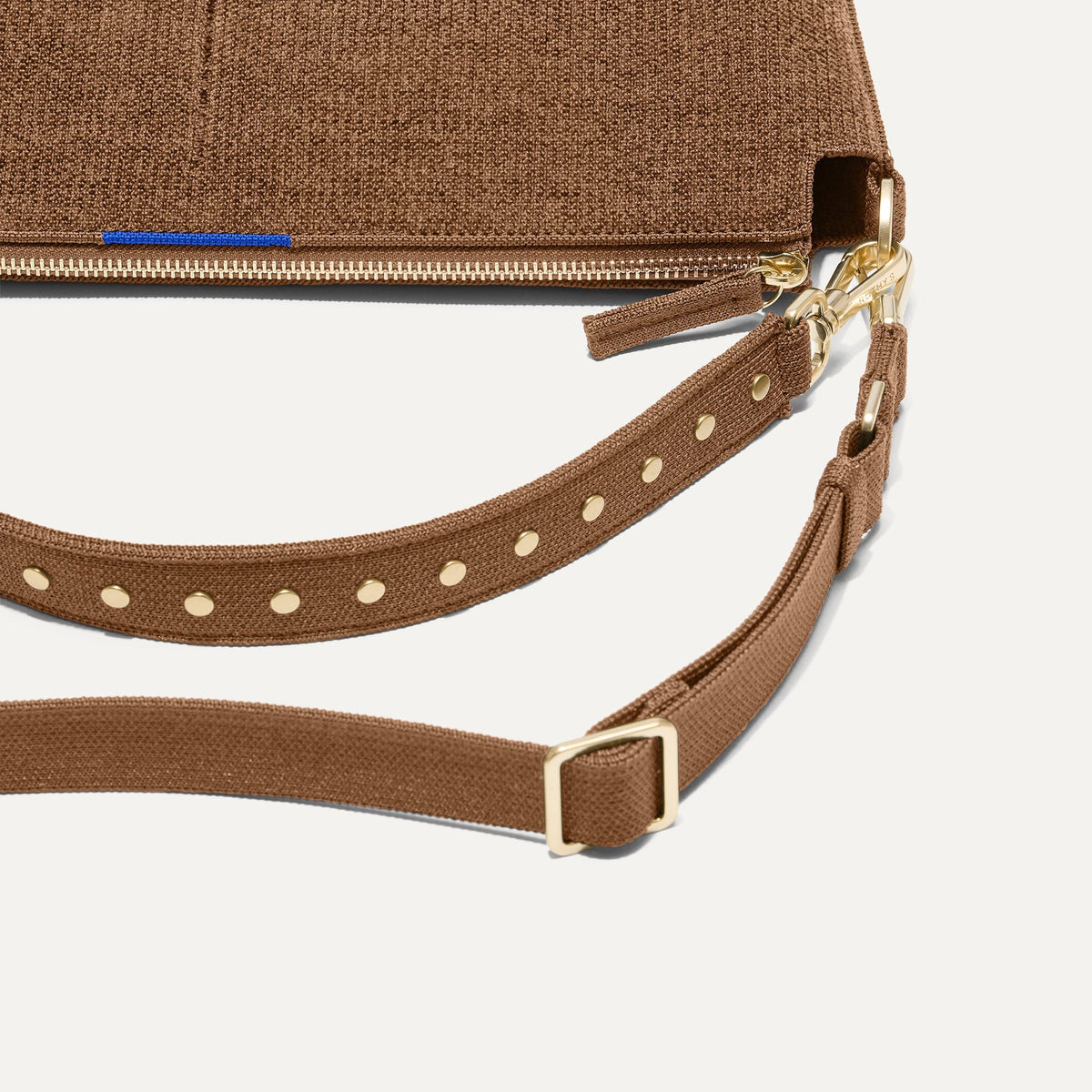Daily Crossbody in Revelvet™ Cinnamon lying flat, showing the detachable top handle and adjustable crossbody strap.