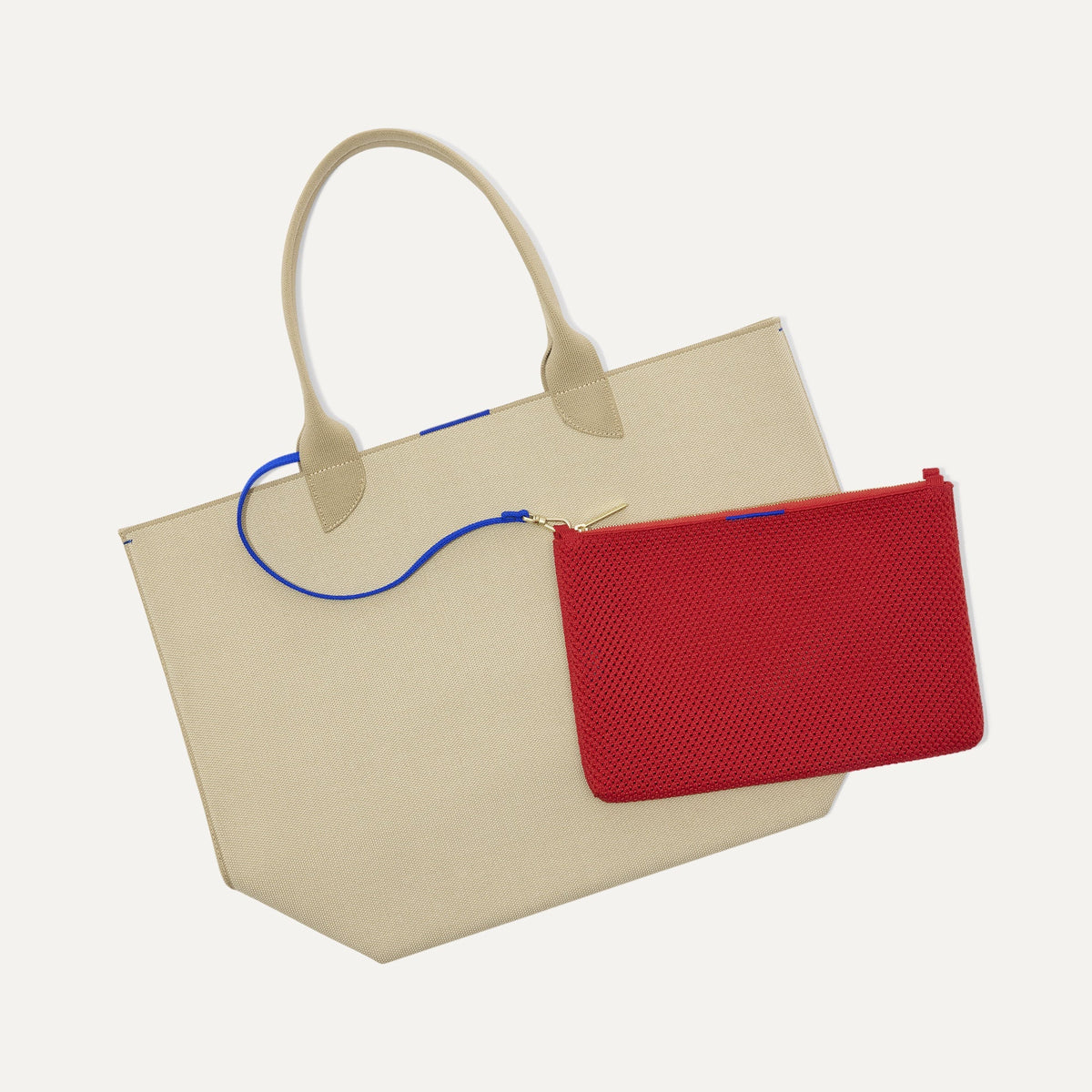 Overlay:: Clips onto The Lightweight Tote key leash. | Alt:: An image of The Convertible Clutch in Scarlet Open Knit clipped to The Lightweight Tote key leash.