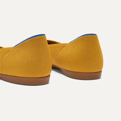 Close up of the heel of The Daily Flat in Marigold, with Rothy's signature blue halo.