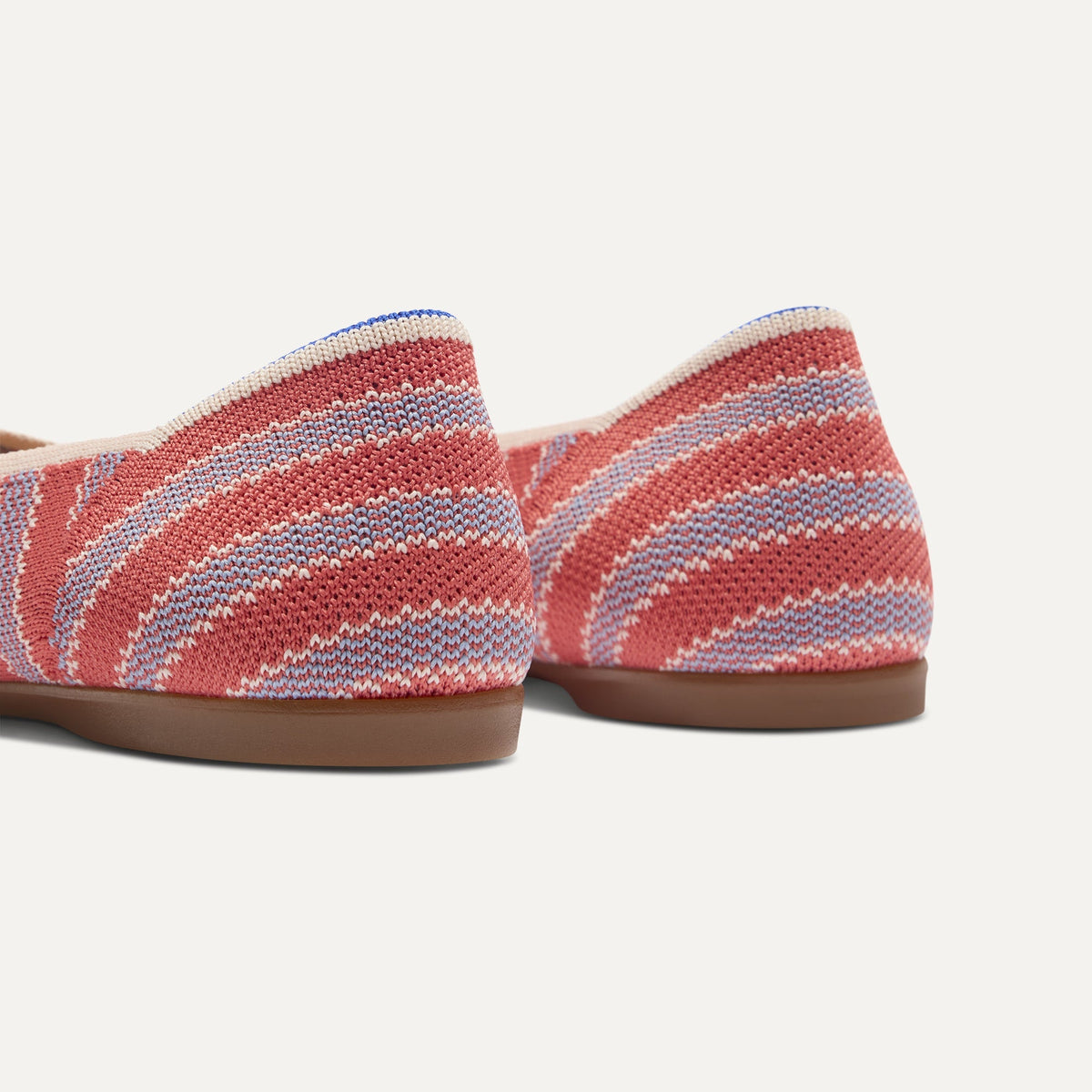 Close up of the heel of The Daily Flat in Sunkiss Stripe, with Rothy's signature blue halo.