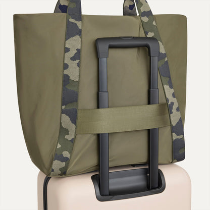 The Travel Tote in Forest, shown attached to a rolling suitcase using the wrap-around band.