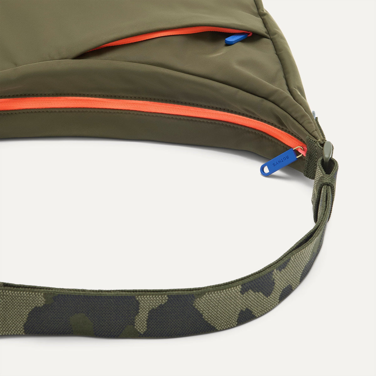 A closeup of The Travel Sling in Forest, showing the smooth zipper closure and soft, flexible handle.