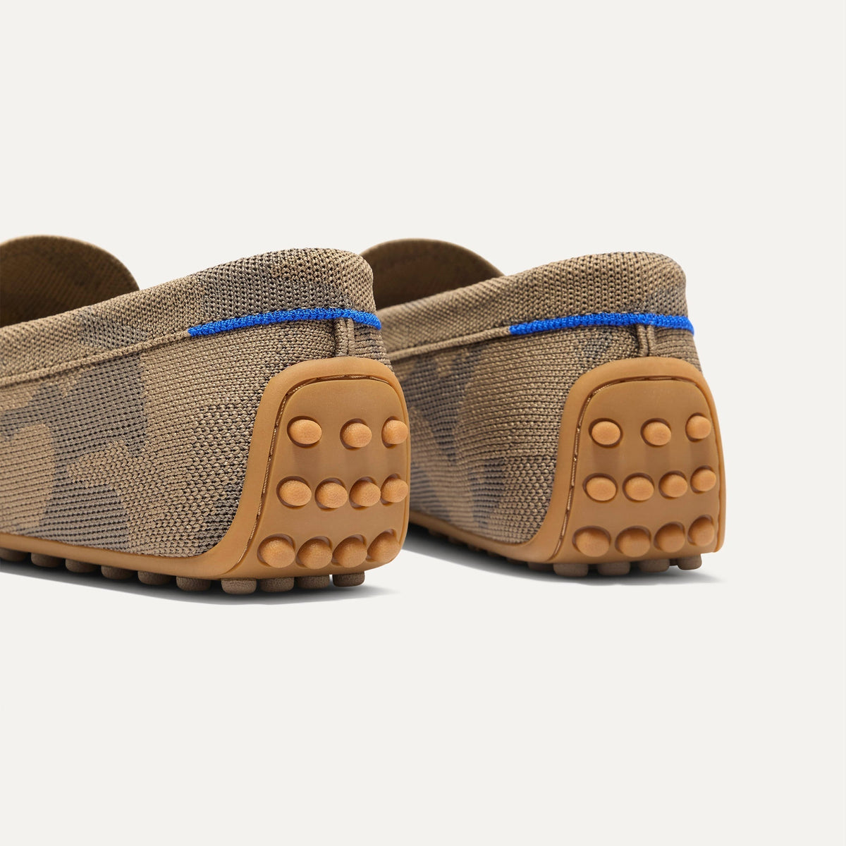Close up of the heel of The Men's Daily Driver in Brown Camo, with raised peg outsoles and Rothy's signature blue halo.
