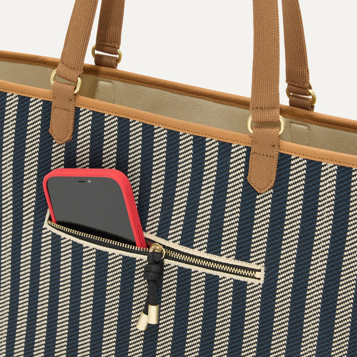 A closeup of The Two-Way Tote in Shadow, focusing on the exterior zip pocket.