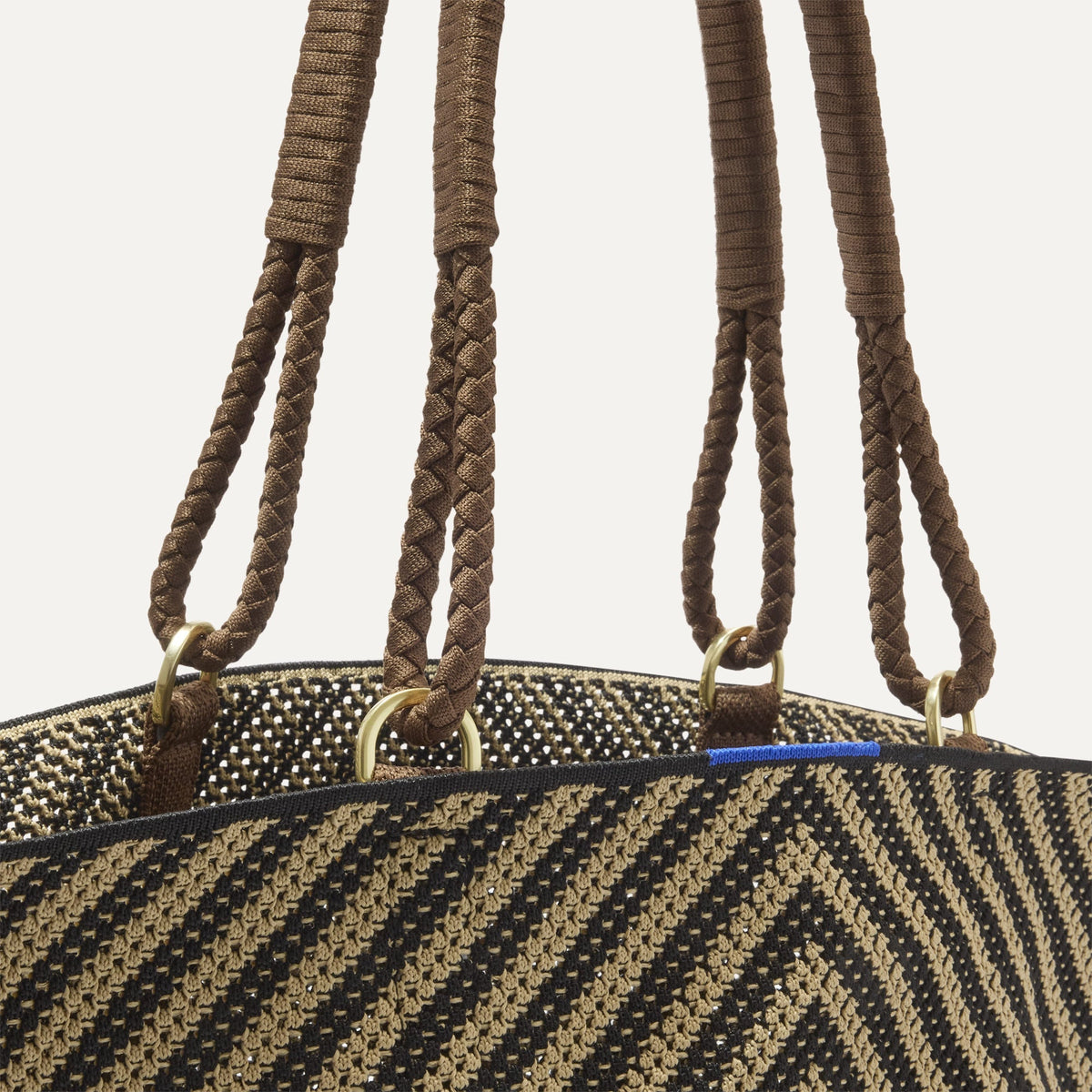 A close up of The Summer Tote in Toffee Chevron focusing on the pocket and handles.