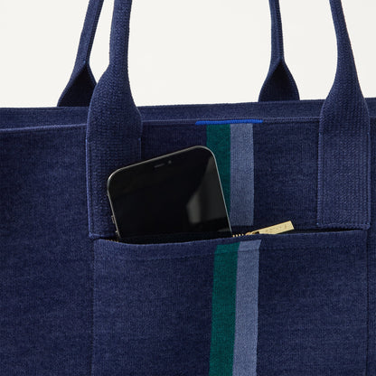 A closeup of The Classic Tote in ReVelvet Peacock, focusing on the exterior zip pocket.