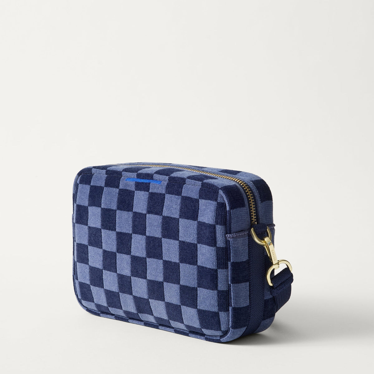 The Crossbody Camera Bag in ReVelvet™ Blue Ink, shown from the side.